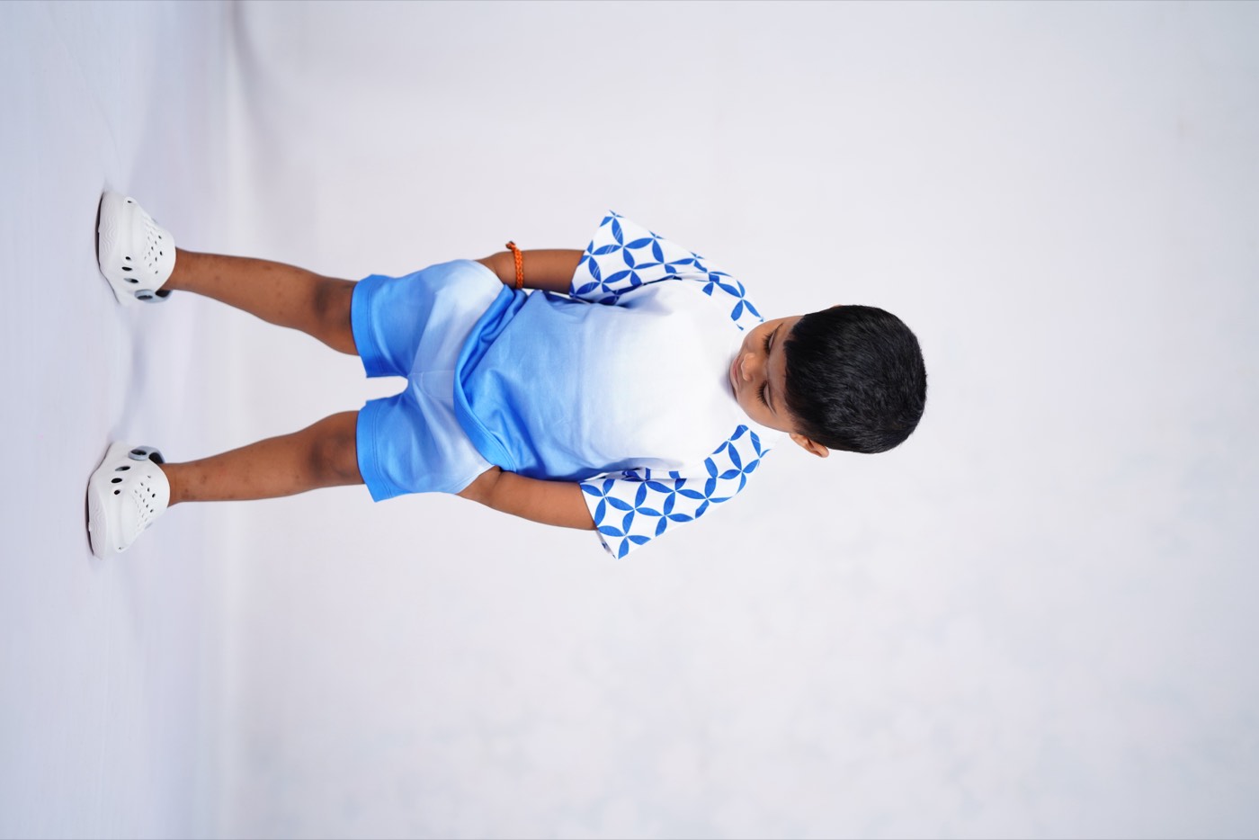 A child in Pangea & Co.'s blue Birdsong dress set from the Neelam collection
